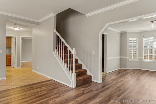 stairway featuring crown molding, hardwood / wood-style floors, and a textured ceiling