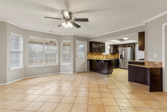 kitchen with tasteful backsplash, light tile patterned floors, dark brown cabinetry, kitchen peninsula, and stainless steel refrigerator with ice dispenser