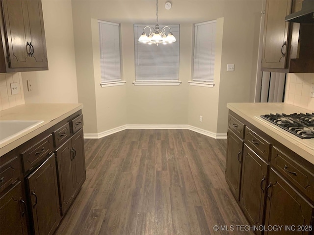 kitchen with backsplash, dark hardwood / wood-style floors, hanging light fixtures, and extractor fan