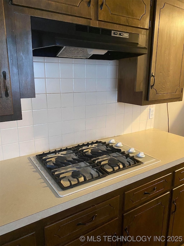 kitchen with dark brown cabinetry, stainless steel gas cooktop, and tasteful backsplash