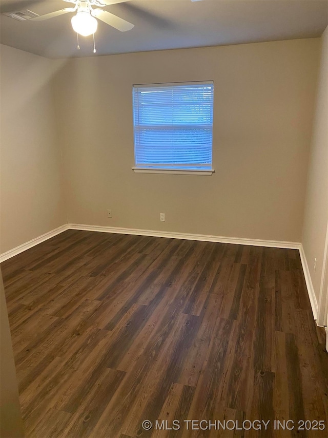 spare room with ceiling fan and dark hardwood / wood-style flooring