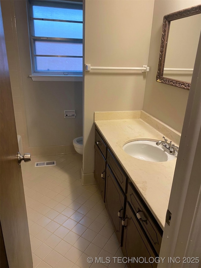 bathroom featuring tile patterned flooring, vanity, and toilet