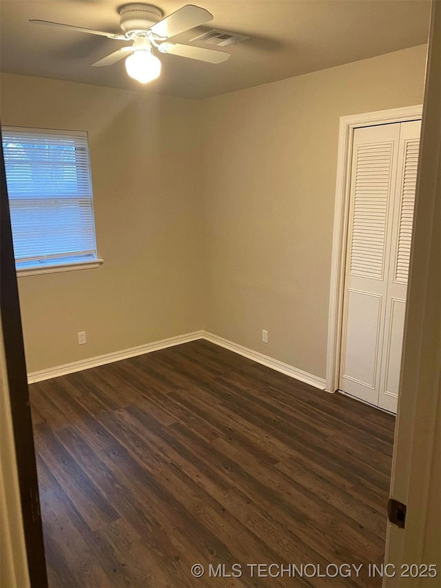 empty room with dark hardwood / wood-style floors and ceiling fan