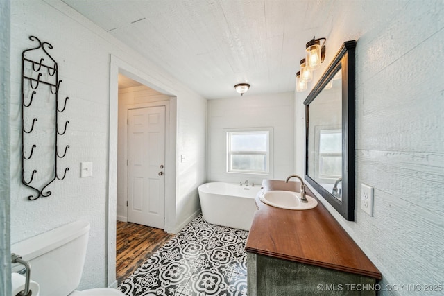 bathroom with tile patterned floors, a bath, toilet, and sink