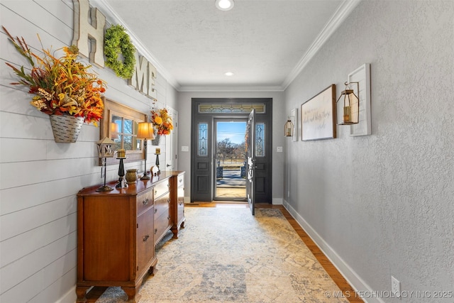 interior space featuring wood-type flooring, a textured ceiling, and crown molding