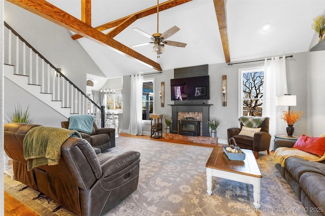 living room with ceiling fan, hardwood / wood-style floors, lofted ceiling with beams, and a brick fireplace