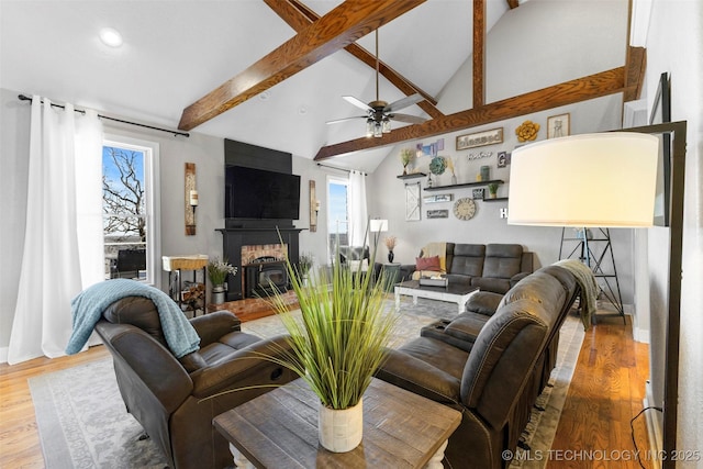 living room with vaulted ceiling with beams, ceiling fan, and hardwood / wood-style flooring