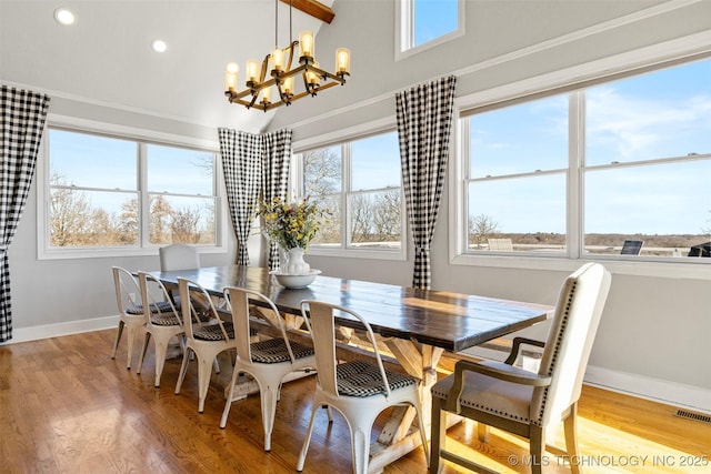 dining area featuring a notable chandelier, a healthy amount of sunlight, and light wood-type flooring