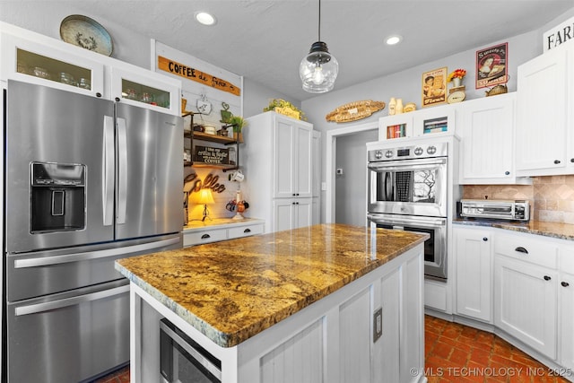 kitchen with white cabinets, pendant lighting, and stainless steel appliances