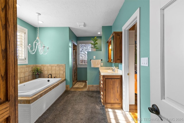 bathroom with plus walk in shower, a notable chandelier, tile patterned floors, a textured ceiling, and vanity