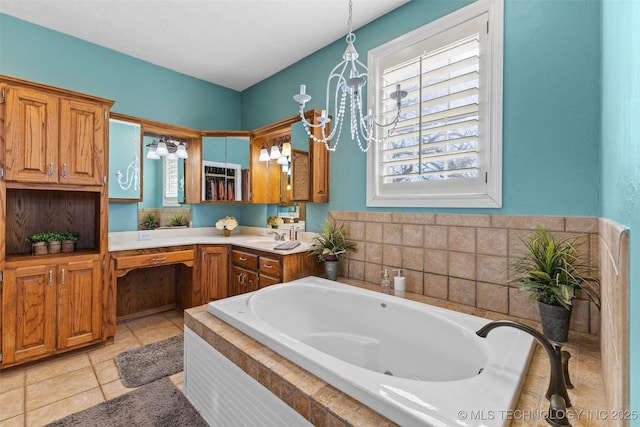 bathroom with tile patterned flooring, vanity, an inviting chandelier, and a bathing tub