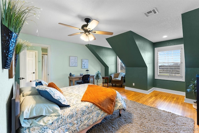 bedroom with hardwood / wood-style floors, a textured ceiling, and ceiling fan