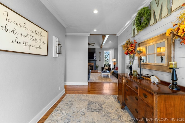 hall with hardwood / wood-style floors and crown molding