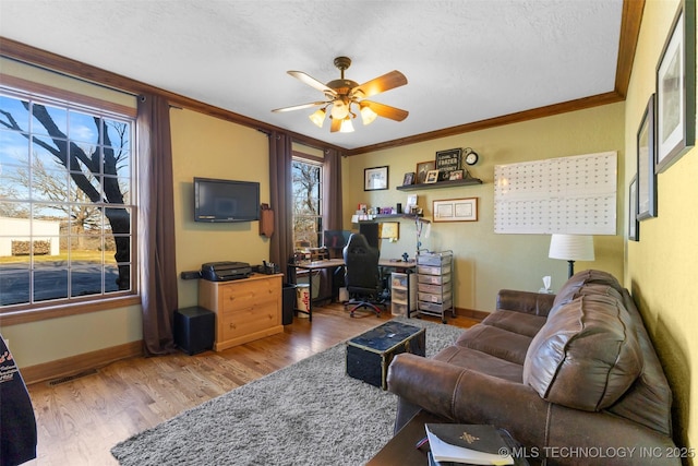 living room with a textured ceiling, ceiling fan, wood-type flooring, and ornamental molding