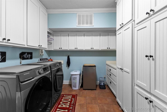 laundry area with washing machine and dryer, cabinets, and ornamental molding