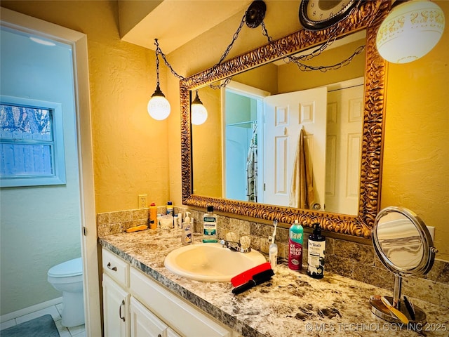 bathroom with toilet, vanity, and tile patterned flooring