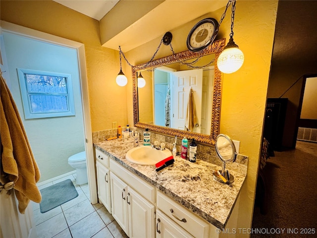 bathroom with toilet, tile patterned floors, and vanity