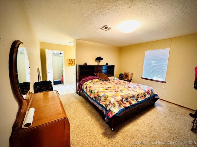 bedroom featuring light carpet and a textured ceiling