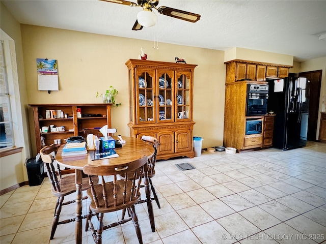 tiled dining room with a textured ceiling and ceiling fan