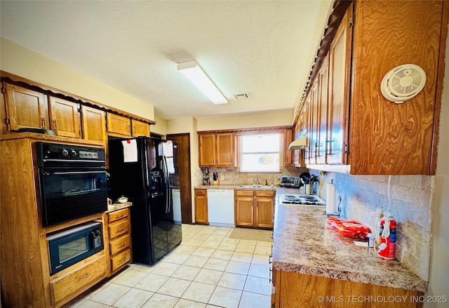 kitchen with a textured ceiling, sink, tasteful backsplash, and black appliances