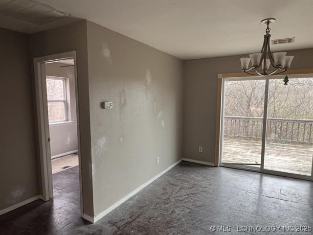 unfurnished dining area featuring an inviting chandelier and plenty of natural light