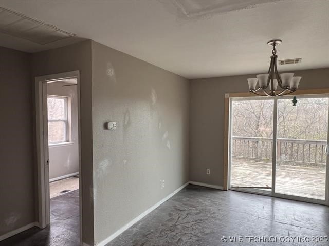 unfurnished dining area featuring a healthy amount of sunlight and an inviting chandelier