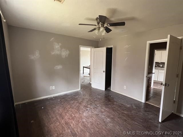 unfurnished bedroom with ceiling fan and dark hardwood / wood-style flooring