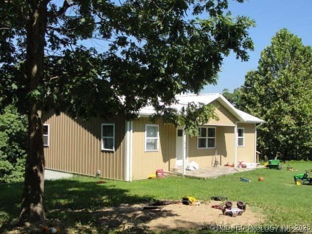 rear view of property featuring a lawn