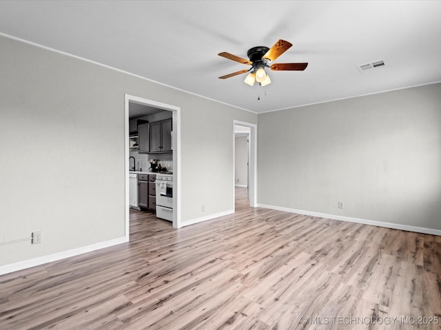 unfurnished living room with ceiling fan, sink, and light hardwood / wood-style flooring