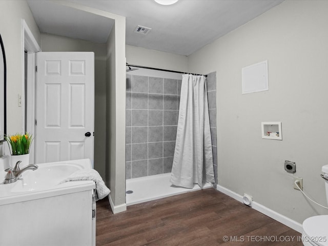 bathroom featuring hardwood / wood-style floors, vanity, toilet, and curtained shower