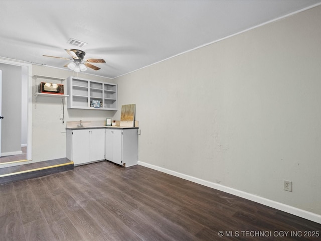 kitchen with white cabinets, dark hardwood / wood-style flooring, ceiling fan, and sink