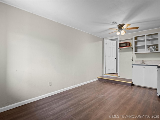 unfurnished room with ceiling fan and dark wood-type flooring