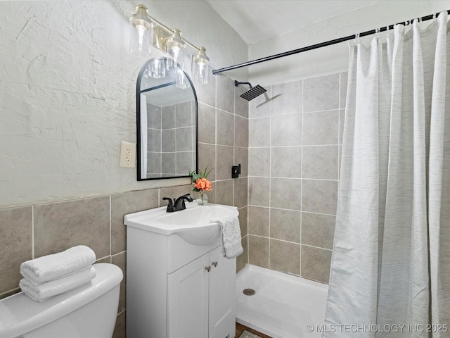 bathroom featuring a shower with curtain, vanity, tile walls, and toilet