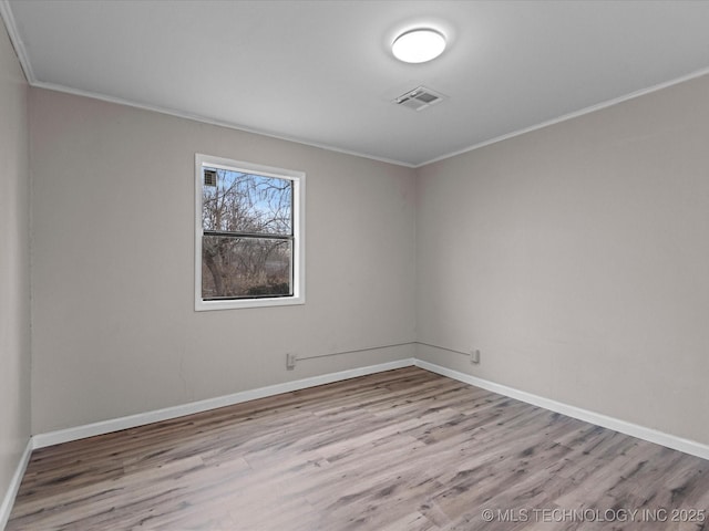 empty room featuring light hardwood / wood-style floors and ornamental molding