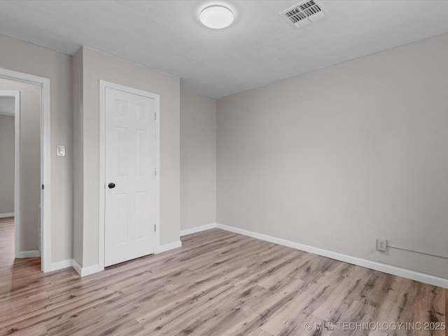 empty room with light hardwood / wood-style flooring