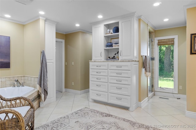 interior space featuring tile patterned flooring, vanity, a tub to relax in, and ornamental molding