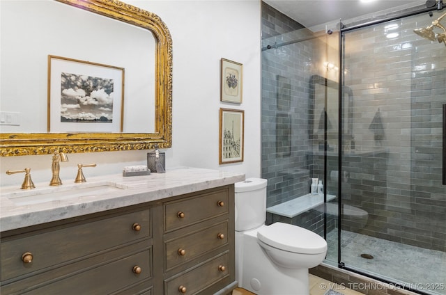 bathroom featuring vanity, toilet, and a shower with shower door