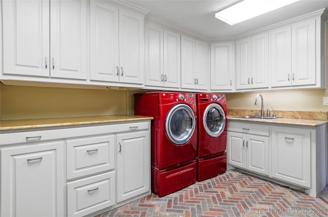 washroom with sink, cabinets, and independent washer and dryer