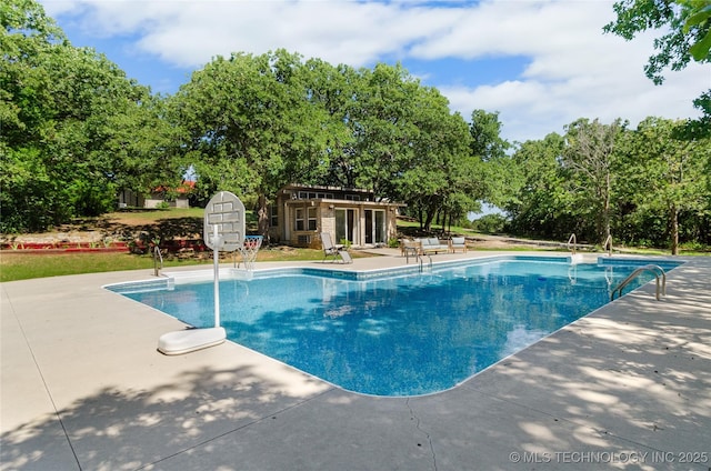 view of swimming pool featuring an outdoor structure and a patio area