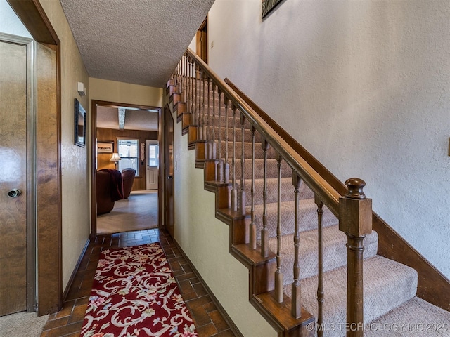 staircase featuring a textured ceiling