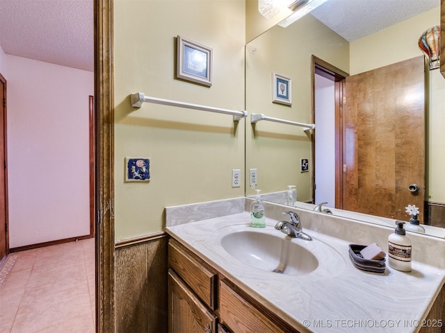 bathroom with wood walls, vanity, and a textured ceiling