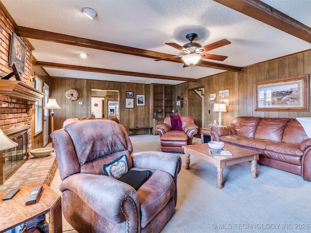 living room with wood walls, beamed ceiling, and a textured ceiling