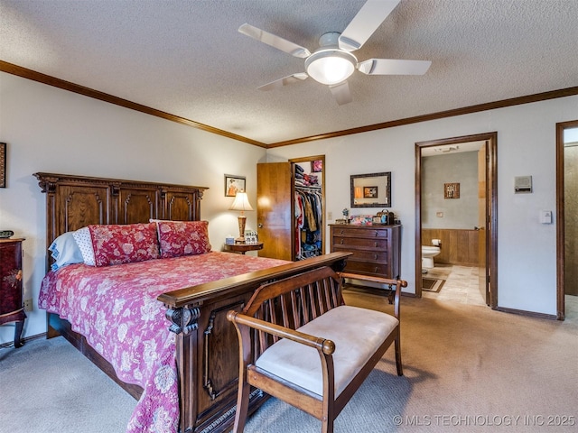 bedroom with a walk in closet, a textured ceiling, connected bathroom, and ceiling fan