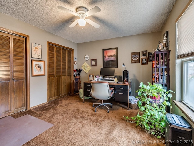 home office featuring ceiling fan, carpet, and a textured ceiling