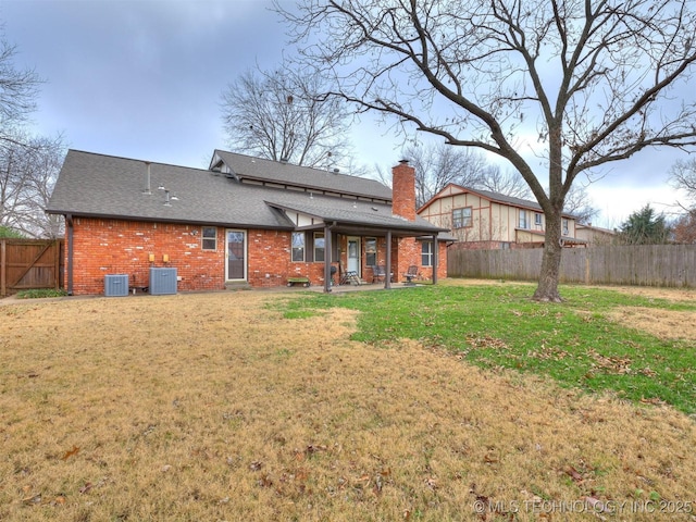 rear view of house featuring central air condition unit, a yard, and a patio