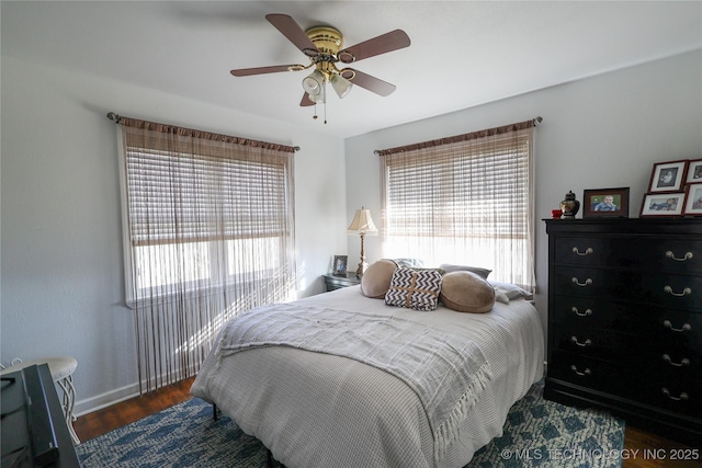 bedroom featuring multiple windows, ceiling fan, and dark hardwood / wood-style flooring