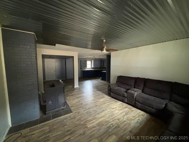 unfurnished living room with ceiling fan and dark wood-type flooring