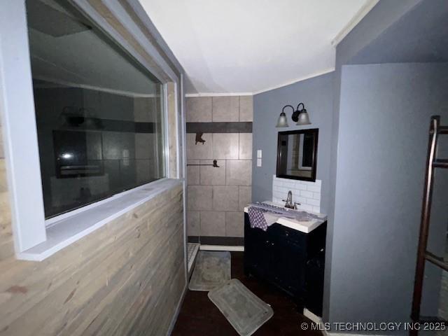 bathroom with vanity, walk in shower, and tile walls