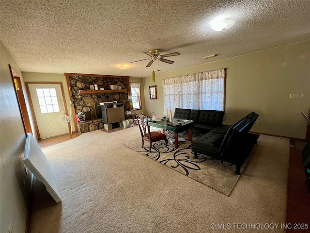 carpeted living room featuring a wealth of natural light, ceiling fan, and a textured ceiling