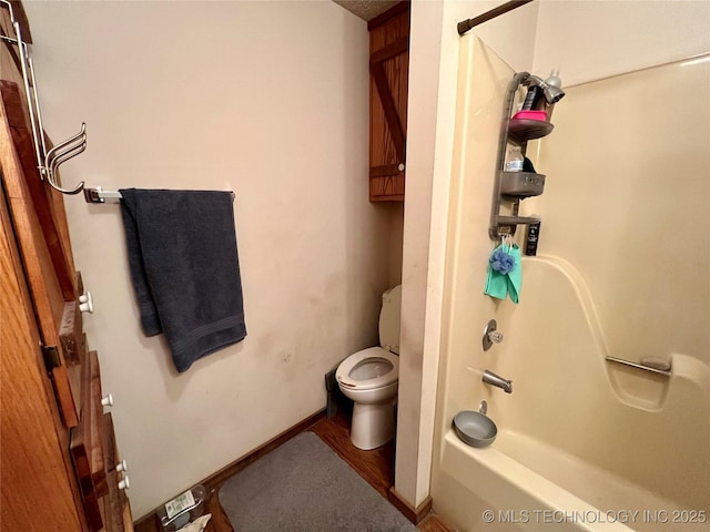 bathroom featuring hardwood / wood-style floors, bathtub / shower combination, and toilet